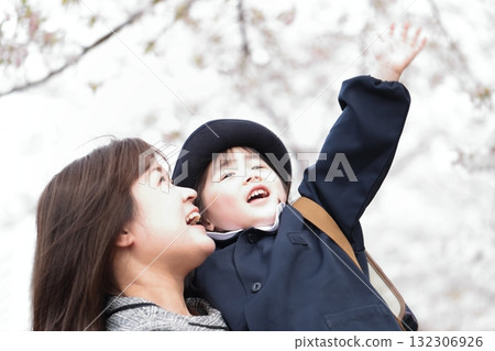 Cherry blossoms and a 3-year-old girl and her mother at the kindergarten entrance ceremony 132306926