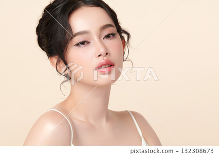 A beautiful young Asian woman with clean, fresh skin against a beige background. Skincare, facial treatment, cosmetology, beauty, and spa. An elegant portrait of an Asian woman. A beautiful young Asian woman with clean, fresh skin against a beige background. Skincare, facial treatment, cosmetology, beauty, and spa. An elegant portrait of an Asian woman. 132308673