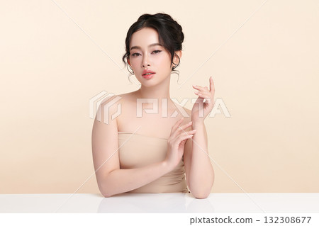 A beautiful young Asian woman with clean, fresh skin against a beige background. Skincare, facial treatment, cosmetology, beauty, and spa. An elegant portrait of an Asian woman. A beautiful young Asian woman with clean, fresh skin against a beige background. Skincare, facial treatment, cosmetology, beauty, and spa. An elegant portrait of an Asian woman. 132308677