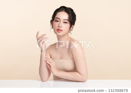A beautiful young Asian woman with clean, fresh skin against a beige background. Skincare, facial treatment, cosmetology, beauty, and spa. An elegant portrait of an Asian woman. A beautiful young Asian woman with clean, fresh skin against a beige background. Skincare, facial treatment, cosmetology, beauty, and spa. An elegant portrait of an Asian woman. 132308678