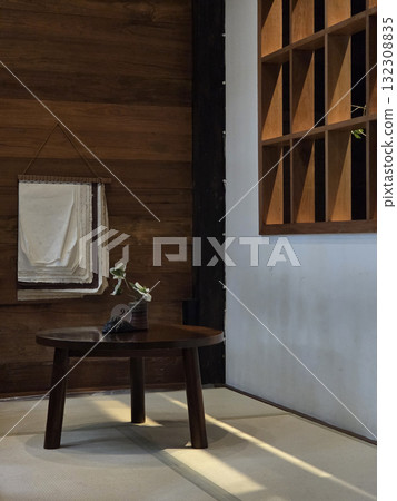 cozy interior featuring wooden table, stacked papers, and wall shelf. warm wooden floor and minimalist design create serene atmosphere 132308835