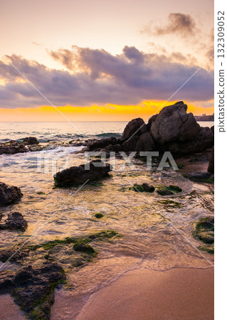 european sea beach with sand and rock at dawn. beautiful seascape of bulgaria in morning light. vacation background in romantic orange glow. dramatic sky with cloud european sea beach with sand and rock at dawn. beautiful seascape of bulgaria in morning light. vacation background in romantic orange glow. dramatic sky with cloud 132309052