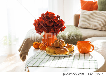 Autumn Living Room with Sofa, Pillows and Pumpkin Cinnamon Buns on Coffee Table 132309514