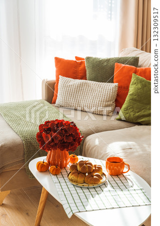 Autumn Living Room with Sofa, Pillows and Pumpkin Cinnamon Buns on Coffee Table Autumn Living Room with Sofa, Pillows and Pumpkin Cinnamon Buns on Coffee Table 132309517