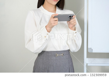Woman operating a smartphone 132309959