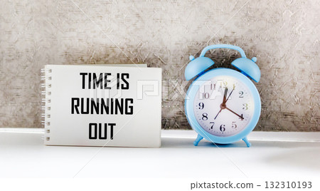 clock and notepad with the inscription "time is running out", highlighted on a light background 132310193