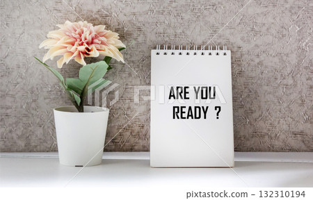 The text You are ready is written on a notebook with a flower on a light background 132310194