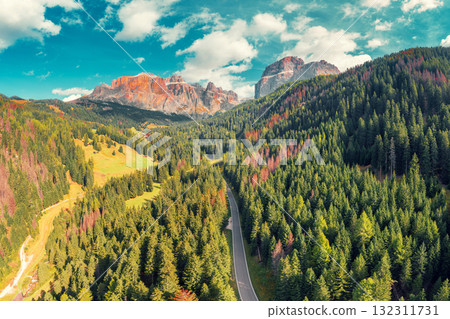 Panoramic aerial view of mountain valley with highway and rocks on a sunny day. Sella Towers Rocks against the sky. Dolomites Road toward the Sella Pass. The dolomites in South Tyrol, Italy 132311731