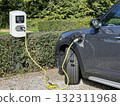 Electric car charging at outdoor station with yellow cable in eco-friendly park slot 132311968