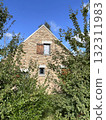 brick house with window blinds behind trees 132311983
