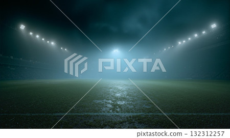 Football field enveloped in thick mist during evening hours, creating an eerie and mysterious atmosphere at the stadium 132312257