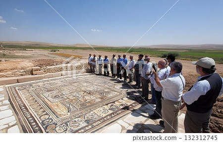 Group of tourists admiring the ancient mosaic floor in an archae 132312745