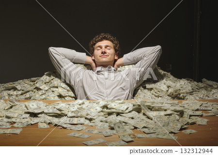 Businessman enjoys a moment of relaxation surrounded by cash in a stylish setting 132312944