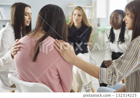 Support group of women comforting member during counseling session indoors Support group of women comforting member during counseling session indoors 132314225