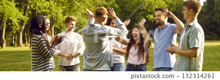 Group of happy young people having fun giving each other high five walking in summer park. Group of happy young people having fun giving each other high five walking in summer park. 132314261
