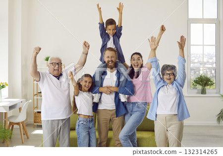 Happy big family parents, grandsparents, kids with hands rising up at home looking at camera. 132314265