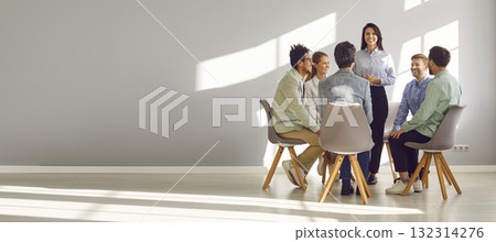 Business coach meeting with a team of young people in an office with a copy space wall 132314276