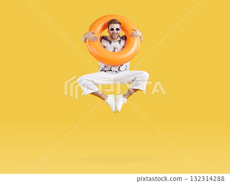 Smiling happy man jumping with inflatable rubber ring 132314288