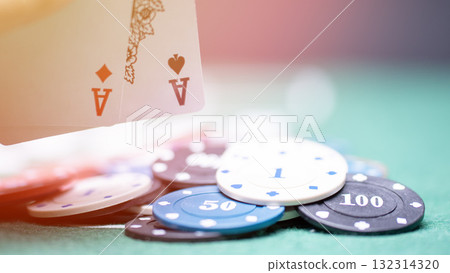 Two aces, two cards on a playing chip set against a black background, representing the concept of casino poker and other card-based gambling games. 132314320