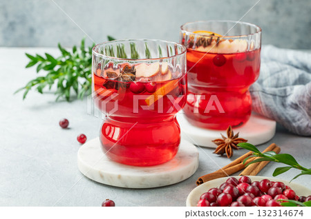 A cranberry drink in a two glasses on a light background with cinnamon, berries close up. 132314674