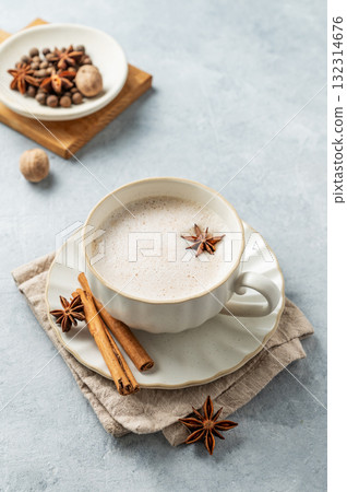 Traditional Indian masala chai tea with milk and spices on a light background. Traditional Indian masala chai tea with milk and spices on a light background. 132314676