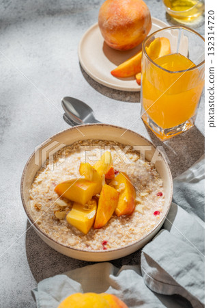 Oatmeal with peaches and nuts  in a bowl on a gray background with honey 132314720