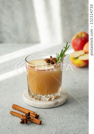 Hot apple cider with cinnamon, anise, and rosemary in glass on a light background with fresh fruits 132314738
