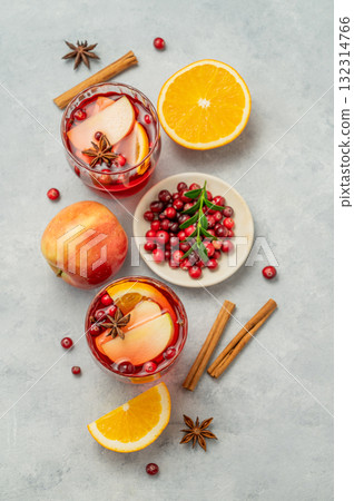 Flat lay of a cranberry drink in a glasses on a light background with cinnamon, berries and fruits. 132314766
