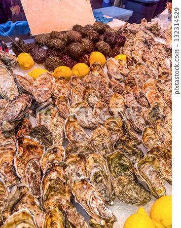 Fresh Oysters and Sea Urchins Displayed with Lemons at Seafood Market Fresh Oysters and Sea Urchins Displayed with Lemons at Seafood Market 132314829