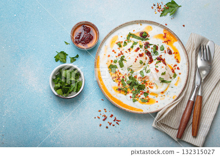 Turkish eggs cilbir, Middle Eastern style breakfast on blue background table top view, space for text Turkish eggs cilbir, Middle Eastern style breakfast on blue background table top view, space for text 132315027