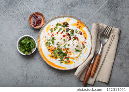 Turkish eggs cilbir, Middle Eastern style breakfast on grey concrete background table top view 132315031