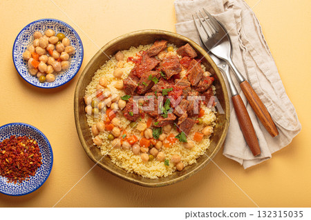 Moroccan couscous with tender meat and chickpea stew in rustic bow top view, Maghreb cuisine Moroccan couscous with tender meat and chickpea stew in rustic bow top view, Maghreb cuisine 132315035