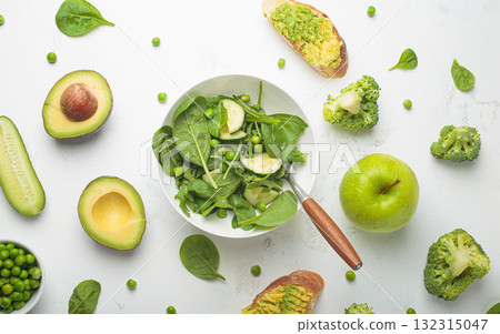 Fresh salad bowl, avocado toasts, raw green vegetables fruit white background top view, diet, vegetarian healthy food 132315047