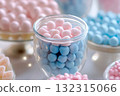 A beautifully arranged dessert table features glass jars filled with pink and blue candies. The detailed focus highlights the vibrant colors, perfect for a gender reveal celebration 132315066