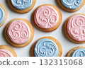Colorful gender reveal cookies are artistically arranged in a flat-lay, featuring intricate designs in pink and blue icing. The soft lighting enhances the delightful treats 132315068