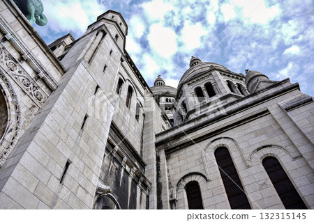Old stone building with towers and cloudy blue sky Old stone building with towers and cloudy blue sky 132315145