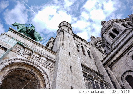 Historic stone architecture with towers and cloudy blue sky Historic stone architecture with towers and cloudy blue sky 132315146