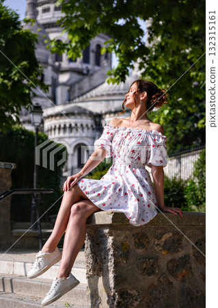 Woman in floral dress relaxing near Sacre Coeur Basilica in Montmartre Paris Woman in floral dress relaxing near Sacre Coeur Basilica in Montmartre Paris 132315161
