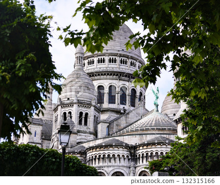 Sacre Coeur Basilica in Paris framed by green trees 132315166