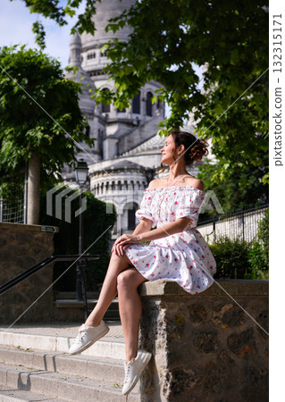 Woman in floral dress sitting on stone stairs near Sacre Coeur Basilica in Paris Woman in floral dress sitting on stone stairs near Sacre Coeur Basilica in Paris 132315171