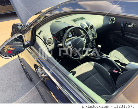 Black sports car interior showcases modern design and sleek features in bright daylight Black sports car interior showcases modern design and sleek features in bright daylight 132315573