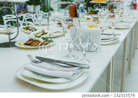 Elegant table setting with delicious food in a bright dining area during a festive gathering 132315579
