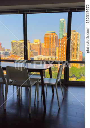 Stunning cityscape view from a modern dining space overlooking tall buildings and blue sky during a sunny afternoon Stunning cityscape view from a modern dining space overlooking tall buildings and blue sky during a sunny afternoon 132315672