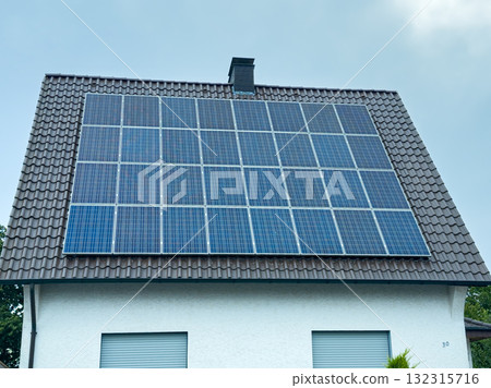Innovative solar panels harnessing renewable energy on a suburban house roof in bright daylight 132315716