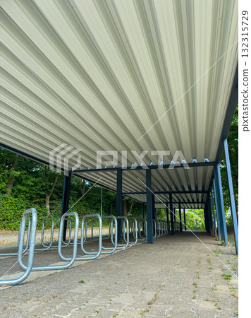 Sheltered bike rack in a quiet area surrounded by greenery, emphasizing a peaceful morning in a hidden spot for cyclists 132315729