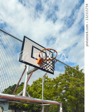 Basketball hoop under partly cloudy sky in outdoor park setting during afternoon Basketball hoop under partly cloudy sky in outdoor park setting during afternoon 132315734