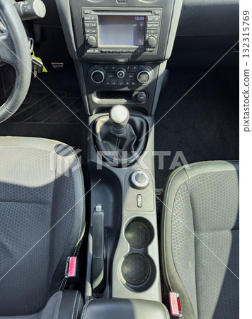 Overview of car interior showcasing the gear stick, console, and seating arrangement during a sunny day 132315769