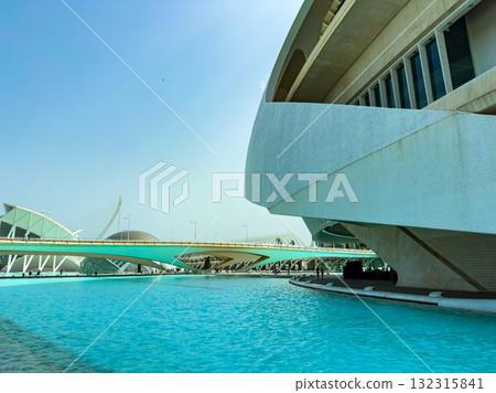Modern architecture harmonizes with nature by the water in a vibrant cityscape under a clear blue sky Modern architecture harmonizes with nature by the water in a vibrant cityscape under a clear blue sky 132315841