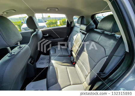 Comfortable interior of a modern vehicle showcasing spacious backseat designed for family trips or daily commutes in a sunny parking lot 132315893
