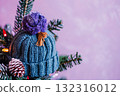 Blue knitted winter hat hanging on Christmas tree as cozy decoration. 132316012
